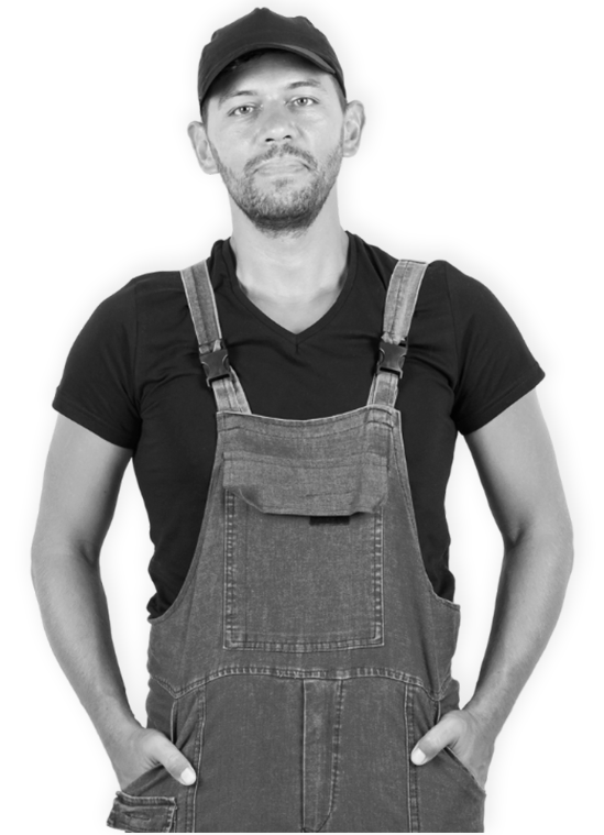 A man in overalls with hands in pockets